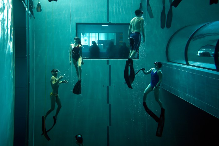 A group of freedivers practice in the pool