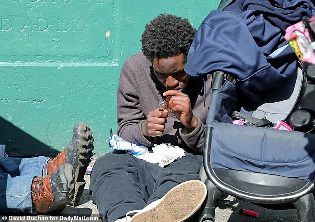 Pictured above is a man on the streets of San Francisco seen taking drugs