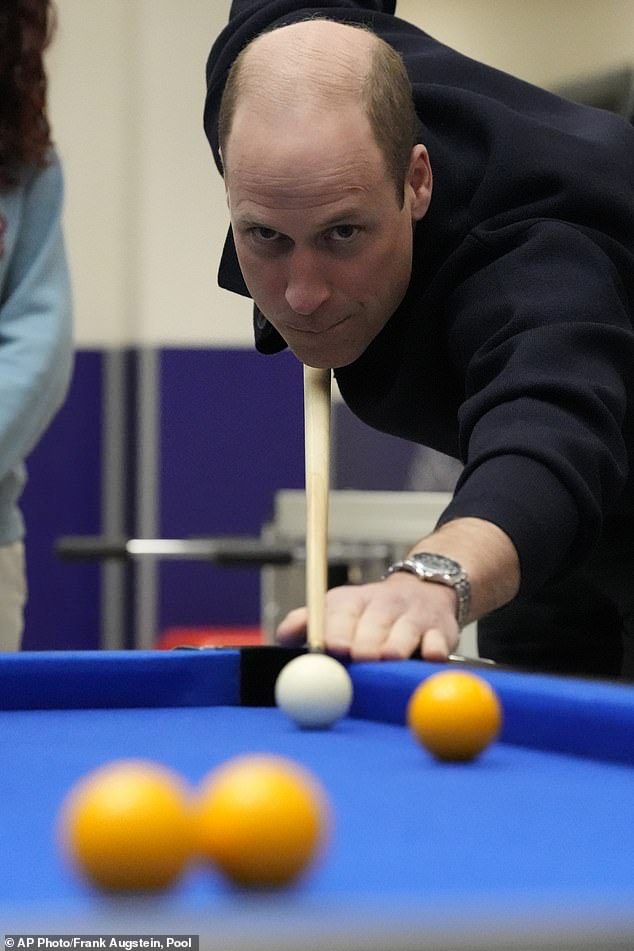 Prince William plays a game of pool during his visit to the West site in White City this morning