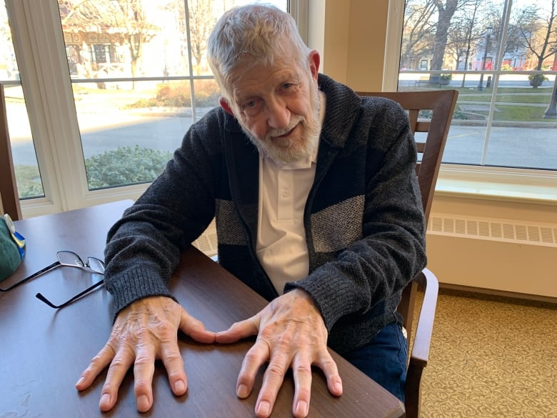 A man shows off his freshly filed nails. 