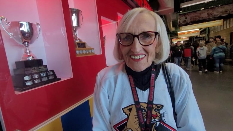 A woman smiles in a hockey arena.