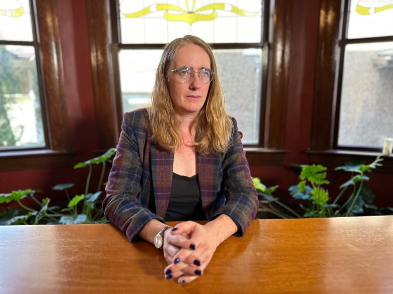 Caroline Colijn, an epidemiologist with Simon Fraser University, sits at a table at her Vancouver home.