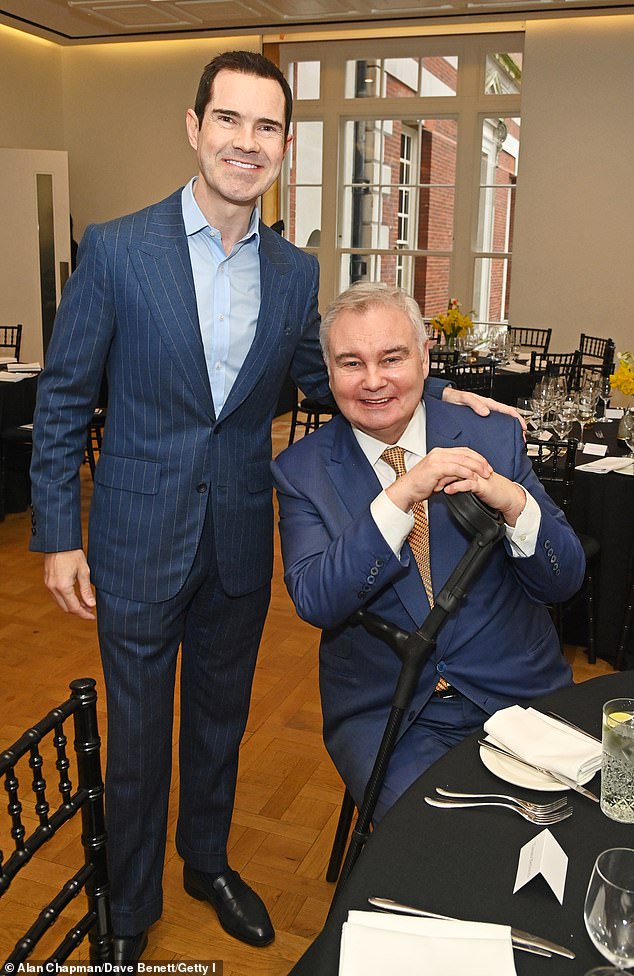 Eamonn Holmes leans on his crutch while posing with Jimmy Carr while Tamara Beckwith wows in tartan as they rub shoulders with politicians at Turn The Tables charity lunch