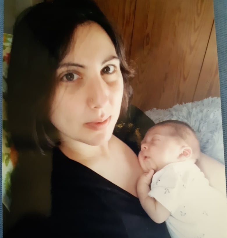 A woman holds a newborn infant against her chest.