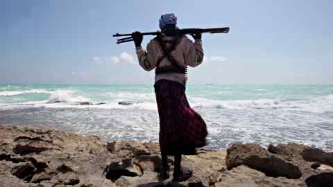 An armed Somali pirate along the coastline