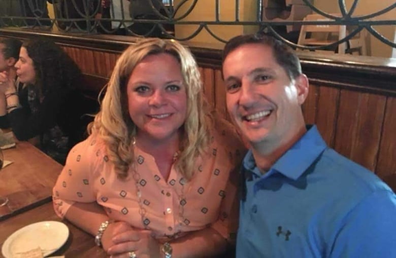 A woman and a man smile together in a restaurant.