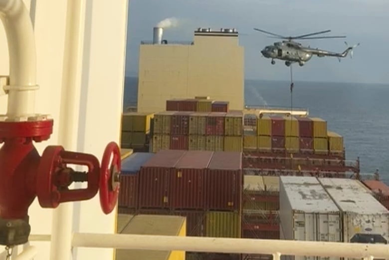  A commando believed to be from Iran's Revolutionary Guard rapels down from a helicopter onto a container ship.