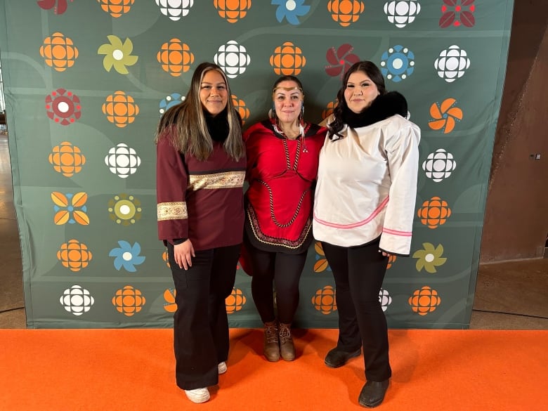 Three women stand in front of a backdrop with CBC logos.