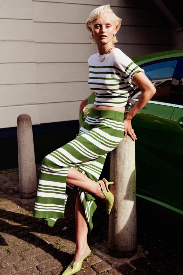 Model wearing a green and white striped T-shirt and skirt