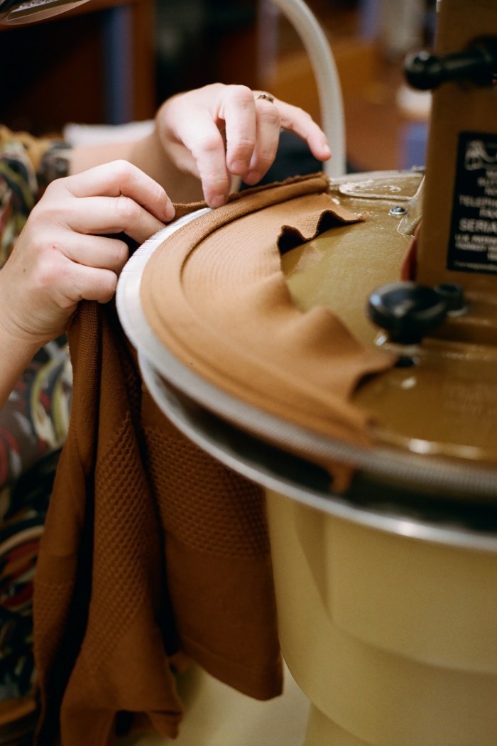 Hands threading yarn on to a circular knitting machine-type equipment