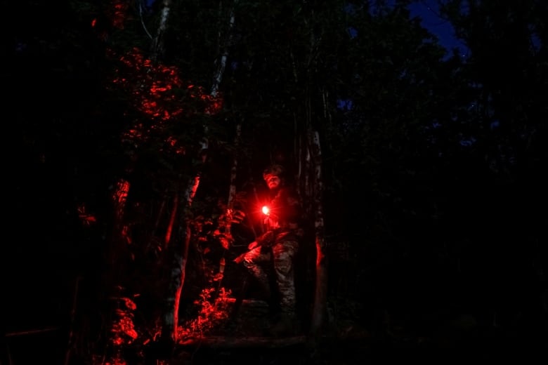 A Ukrainian soldier walks along a front-line position in the Donetsk region.