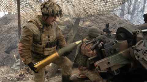 A Ukrainian soldier loads a gun at an undisclosed location in Ukraine