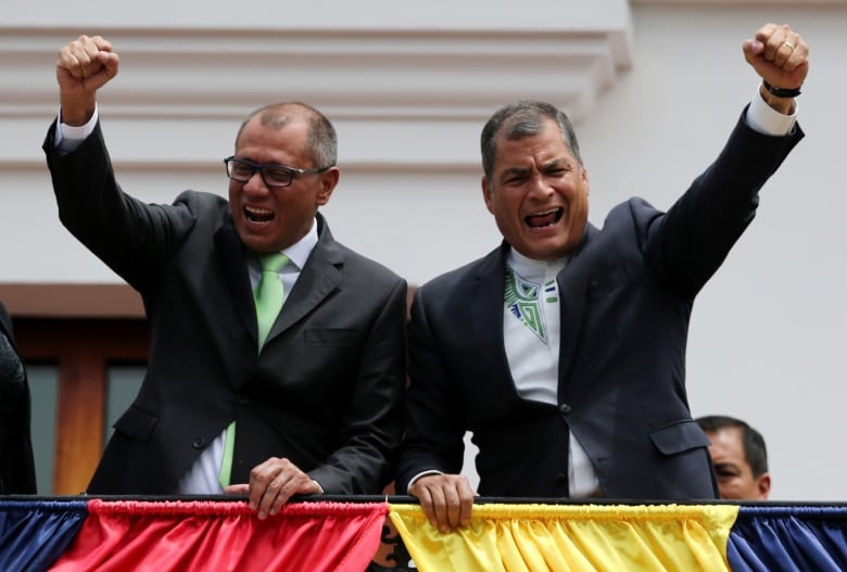 People raise their fist and shout at a balcony.