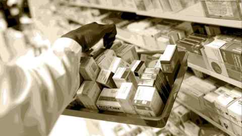 A pharmacist collects medications for prescriptions at a pharmacy in Londo