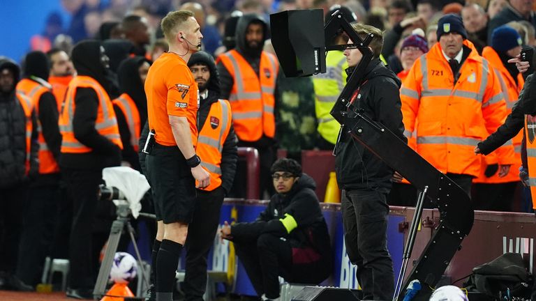 Referee Craig Pawson consults his pitchside monitor