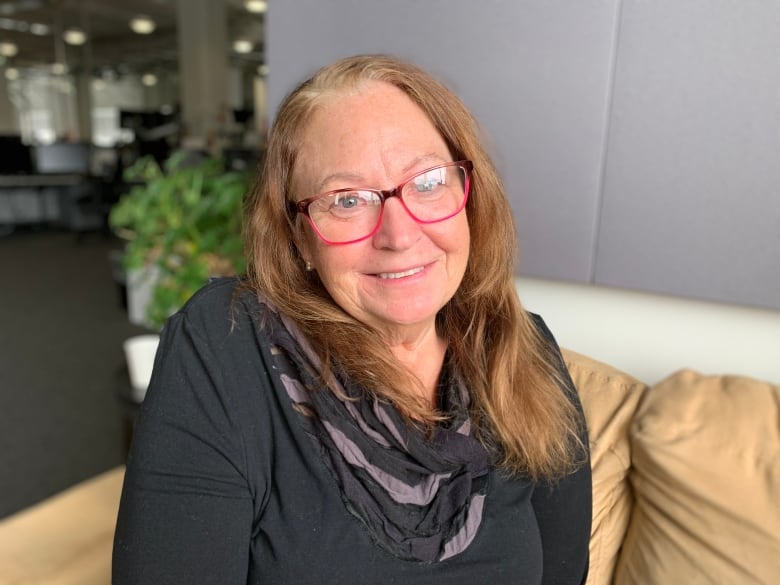 A woman with brown hair and red glasses.