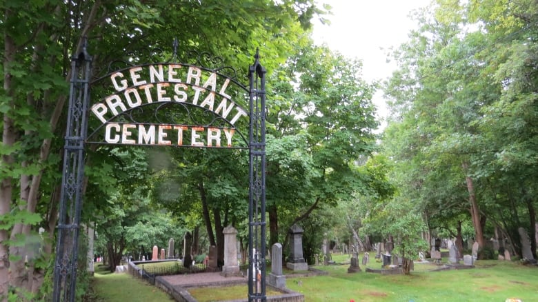 A sign saying General Protestant Cemetery that leads into a graveyard.