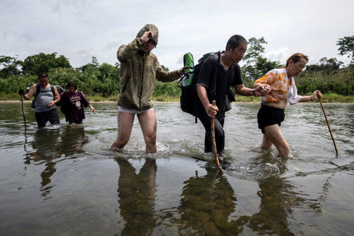 Migrants crossing a river