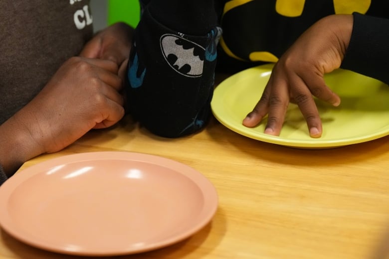 Children's hands touch empty plates