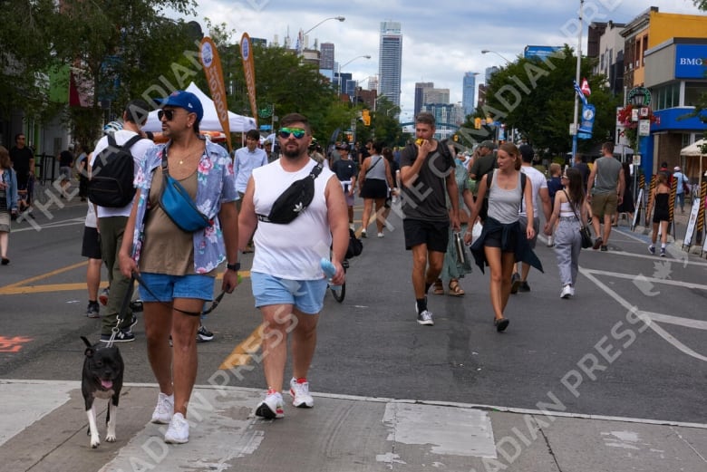 A crowd of people walks on a street. 