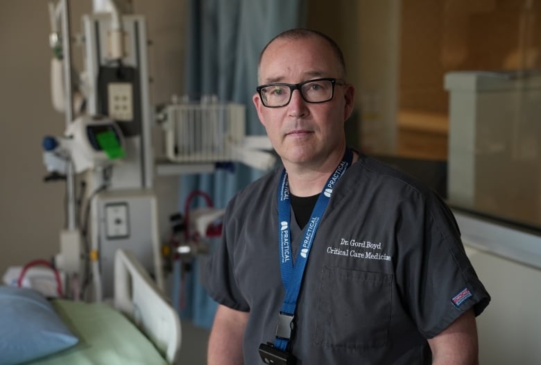 Man wearing scrubs saying Dr. Gord Boyd, Critical Care Medicine, standing in front of an ICU bed.