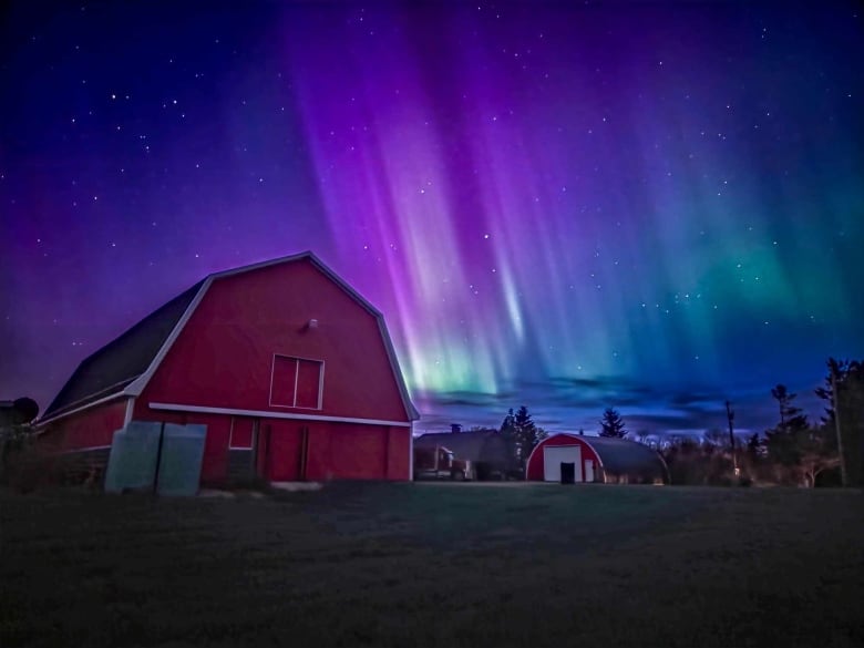 Barn lit up by northern lights