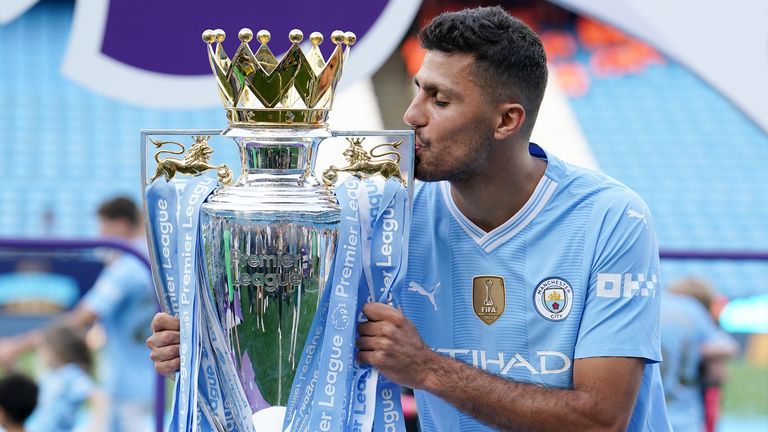 Rodri celebrates with the Premier League trophy