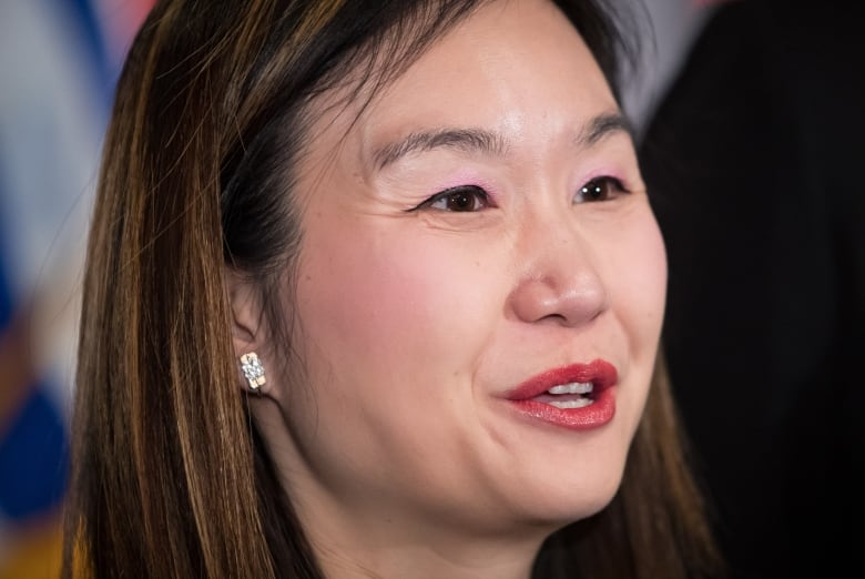 An East Asian woman with long hair smiles