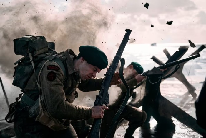 Soldiers advance in a re-enactment of the Sword Beach landing on D-Day in 1944