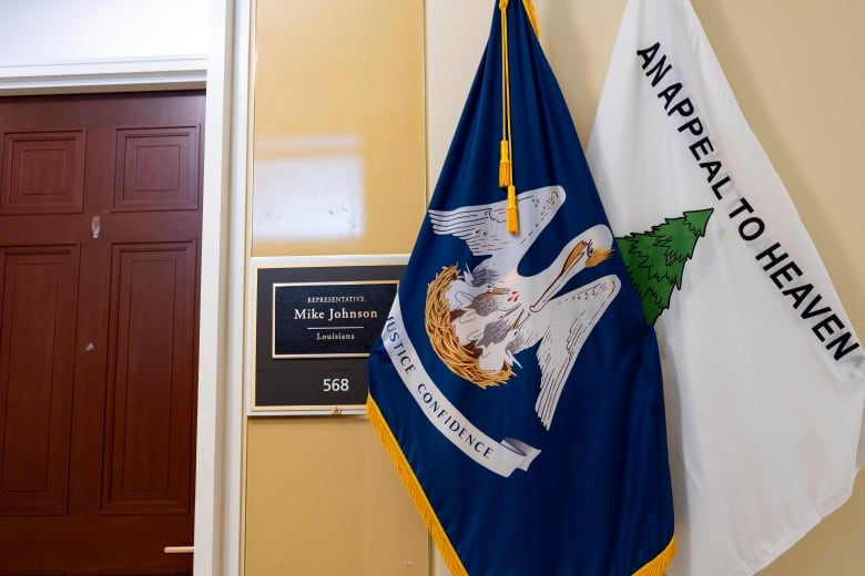 Two flags are shown outside a door in a hallway. One reads, 'An Appeal to Heaven.'