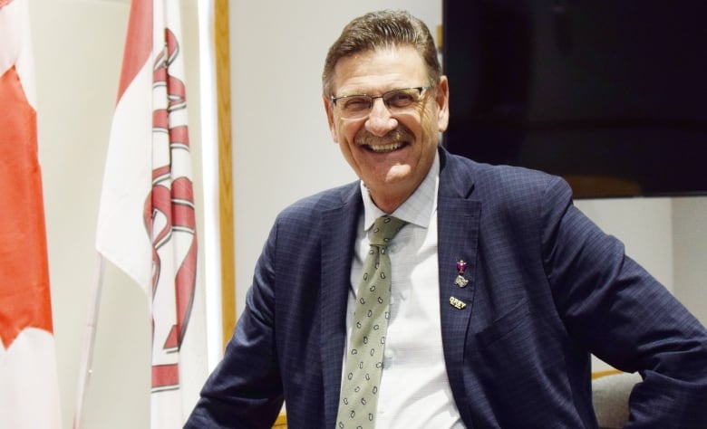 Man in a suit standing in council chambers