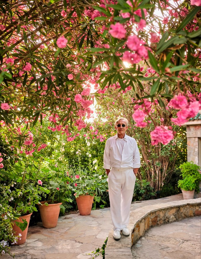 man standing amid pink and red blossom