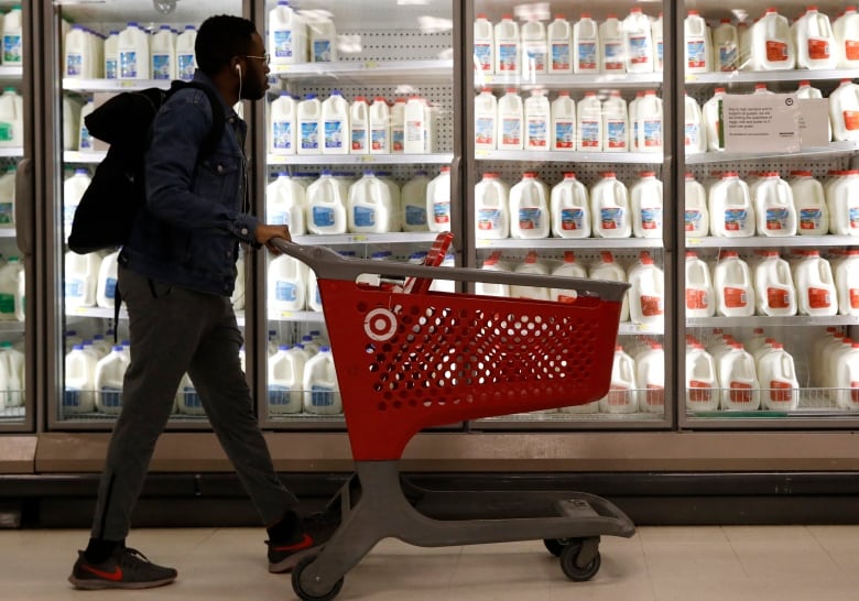 A shopper walks past the milk and dairy display case at a Target store in New York City.