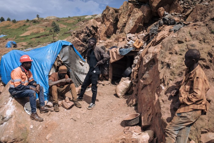 Gold miners and an engineer from the Coomiuki artisanal gold cooperative talk at the entrance to a mining hole in the Luhihi gold mine in the eastern province of South Kivu in the Democratic Republic of Congo