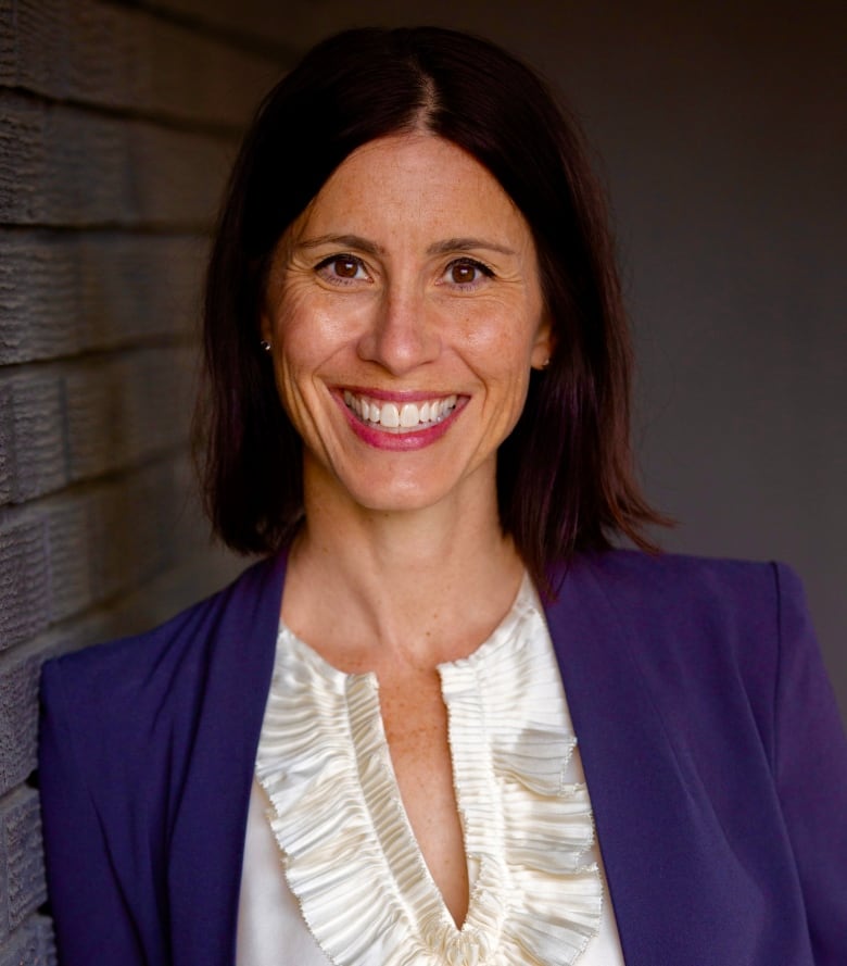 A woman smiles at the camera.