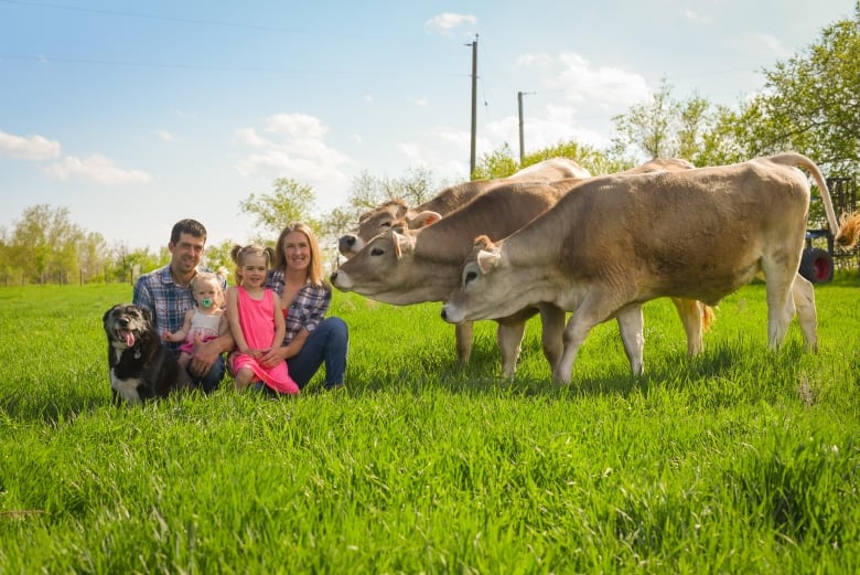 Dairy farming family with some of the cows in Kleefeld, Man.