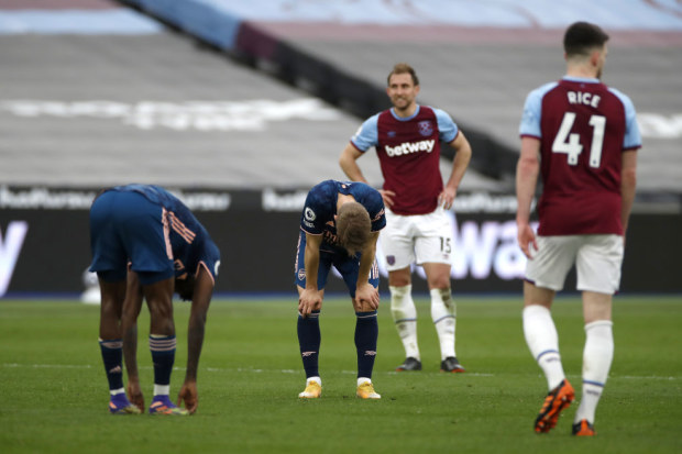 Arsenal's Martin Odegaard (centre) and Nicolas Pepe (left) crouch over tired after the Premier League match.