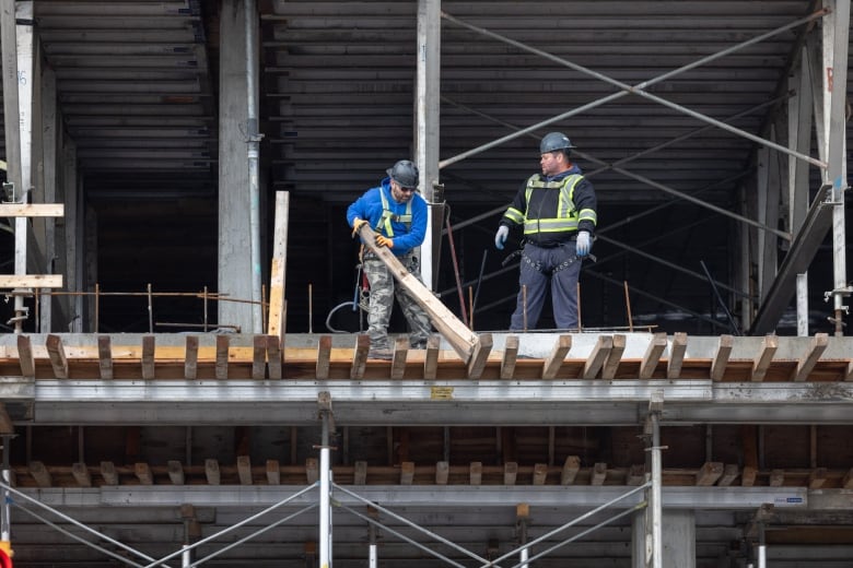 Two men are shown on a worksite. 