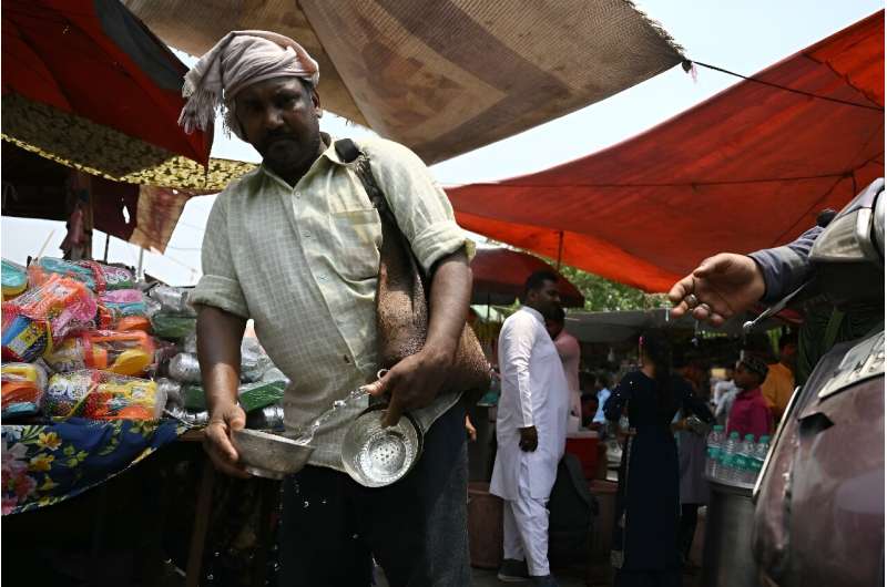 A volunteer distributes water during a hot summer day in Delhi on May 17