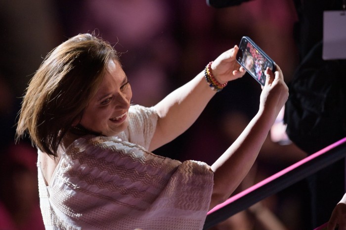 Xóchitl Gálvez holds a smartphone and takes a selfie during her campaign’s closing event at an arena in Monterrey