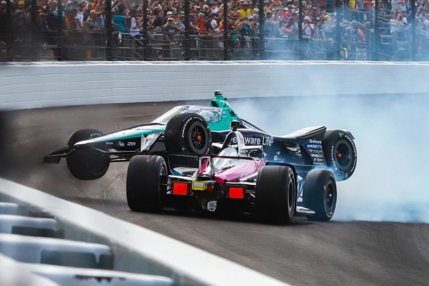 Marcus Ericsson climbs over the nose of Tom Blomqvist after the Meyer Shank Racing car spun on lap one of the 108th Indianapolis 500.