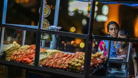 A street vendor sells prawns and sea-food at her kiosk at the Galle Face Beach in Colombo