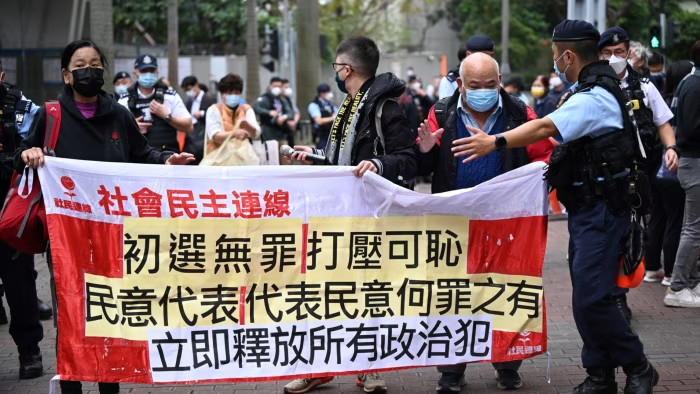 Members of the League of Social Democrats carry a banner outside a court in Hong Kong