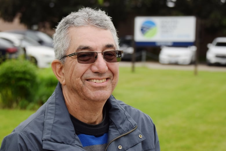 Man sits on bench in front of hospital