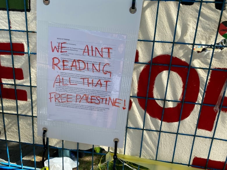 A University of Toronto trespass notice is defaced with the words "We ain't reading all that free Palestine."