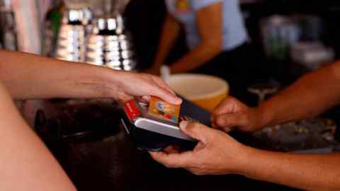 A woman pays with a credit card at a restaurant