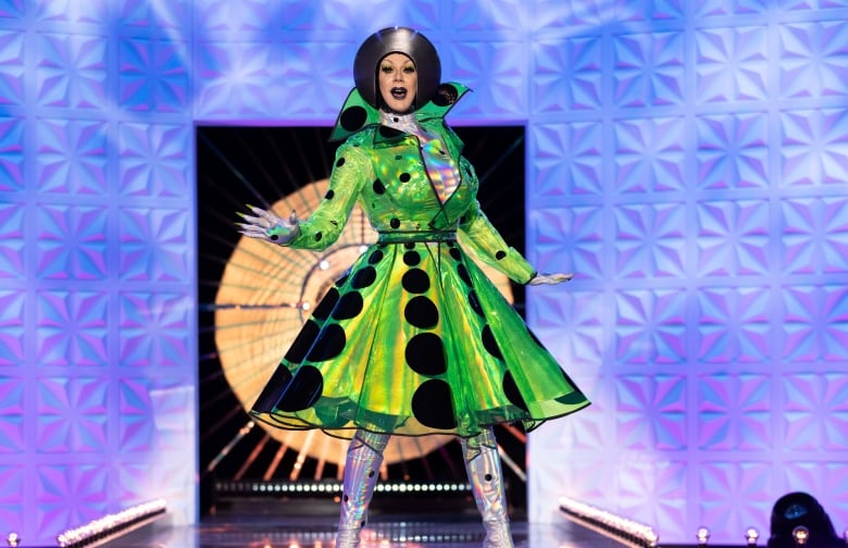 The drag queen Jimbo appears on Ru Paul's Drag Race: UK Versus the World television show. Jimbo is wearing a green dress with black circles.