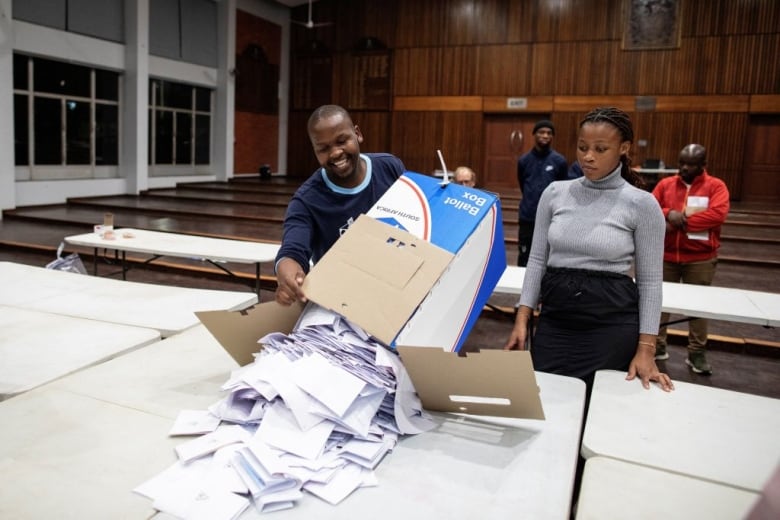 An election worker empties a ballot box.