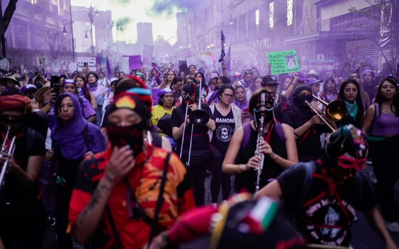 A group of women march in a parade.