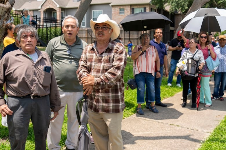 People stand outside a polling station.